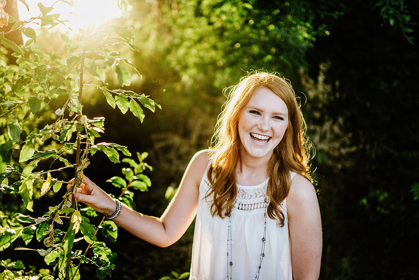 girl in the woods laughing in the sun