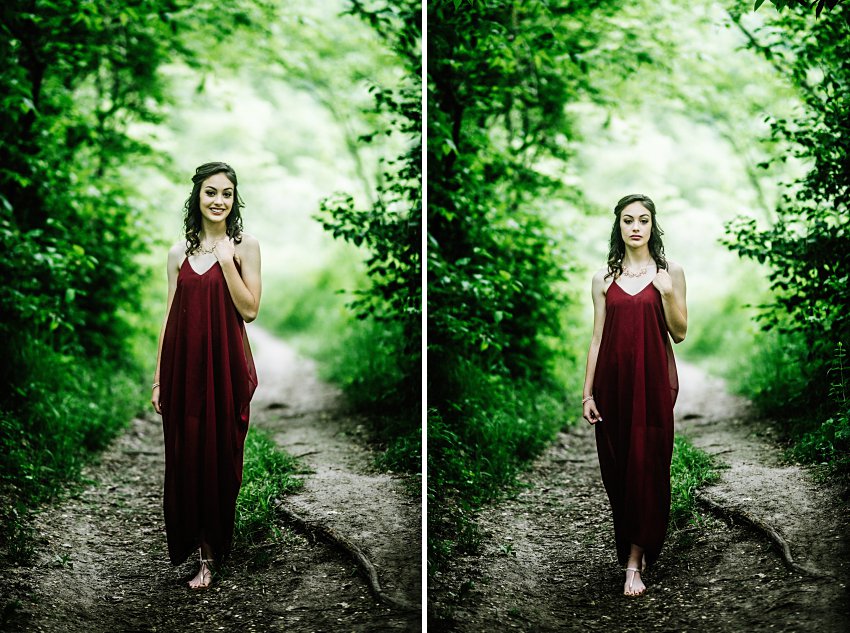 girl in a red dress standing on a path in the woods with trees that make a tunnel