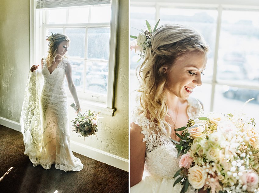 the bride standing in front of a sunlit window with her flowers