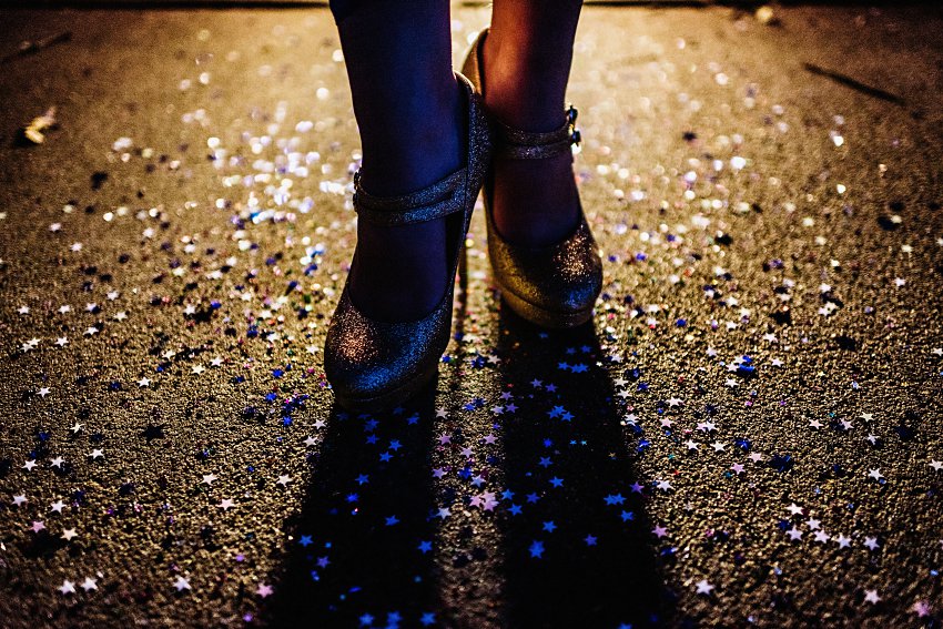sparkly high heels lit from the back standing in glitter
