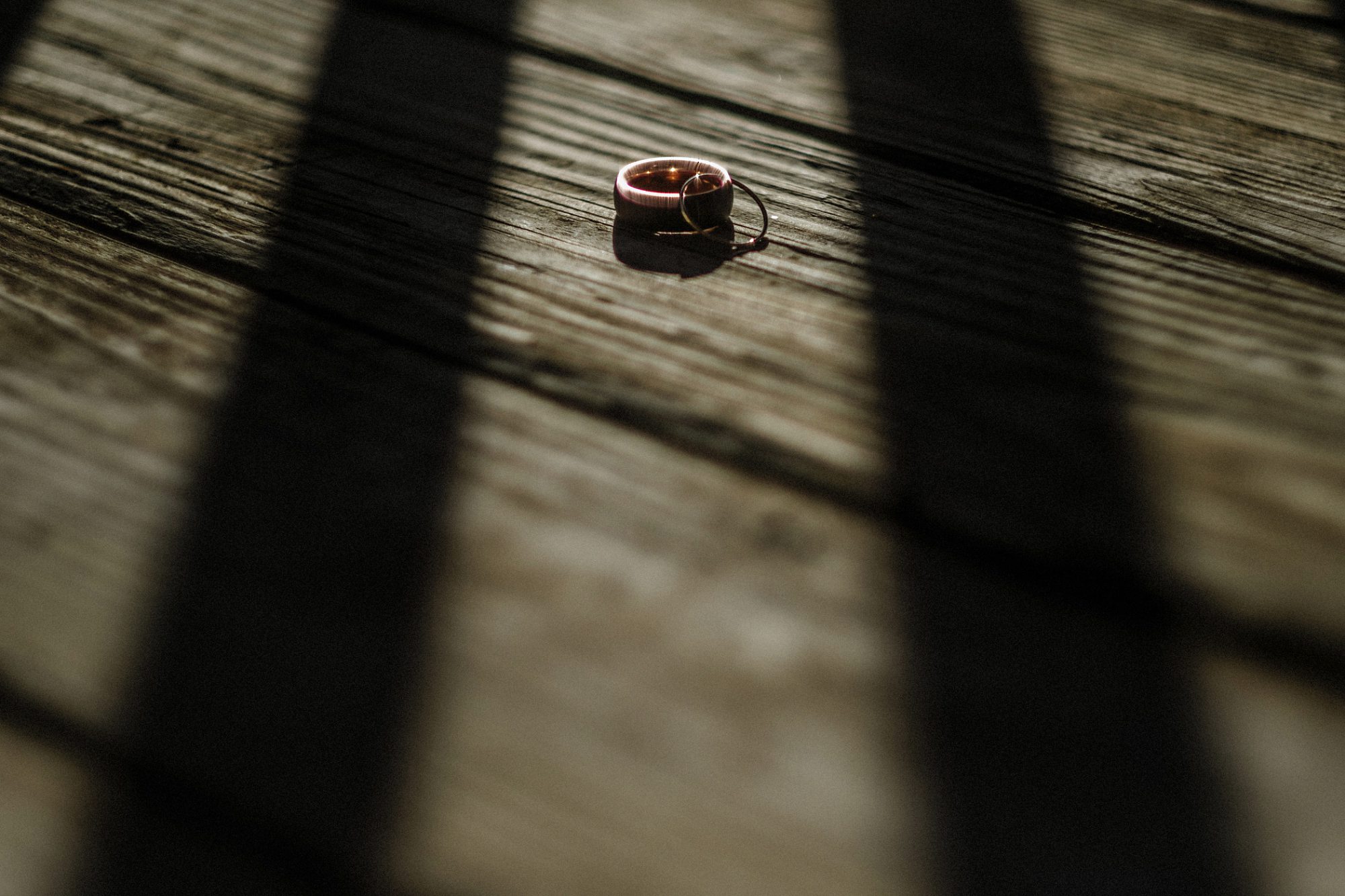 wedding rings, wood floor, shadows, contrast